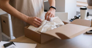 close-up-hands-packing-item