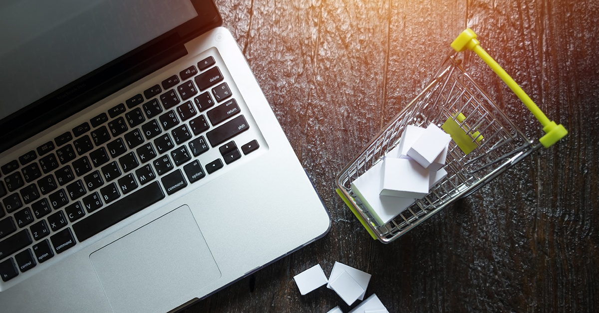 laptop blank screen and hopping cart full of gifts with copyspac